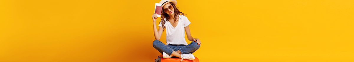 Mujer con mascarilla y maleta de color morado lista para viajar