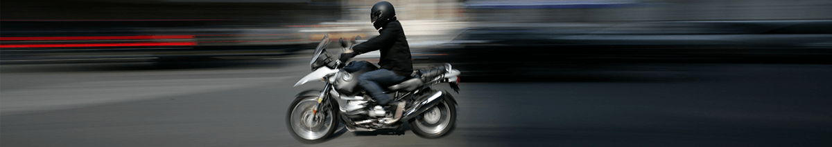 Hombre sobre una moto circulando en la carretera
