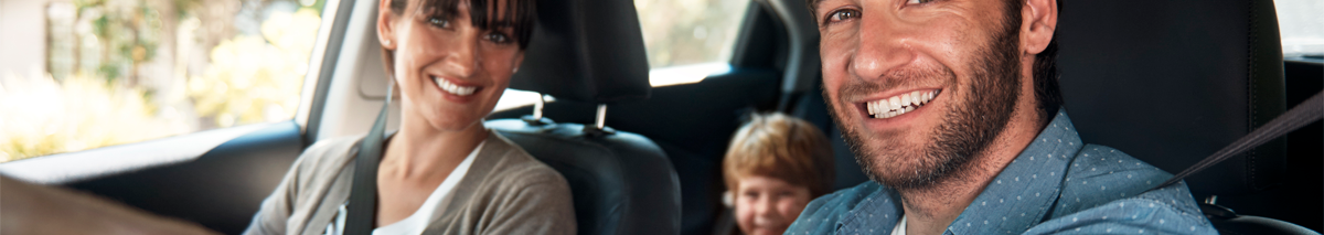 familia sonriendo dentro de un auto